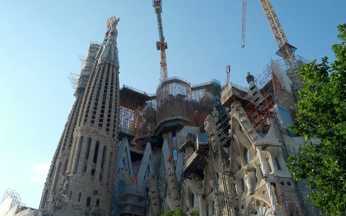 Stone spires of the Sagrada Familia with tower cranes working above the unfinished central towers