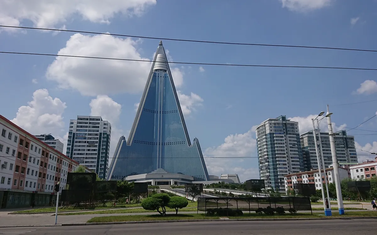 The glass-clad, pyramid-shaped Ryugyong Hotel towering over apartment blocks in Pyongyang