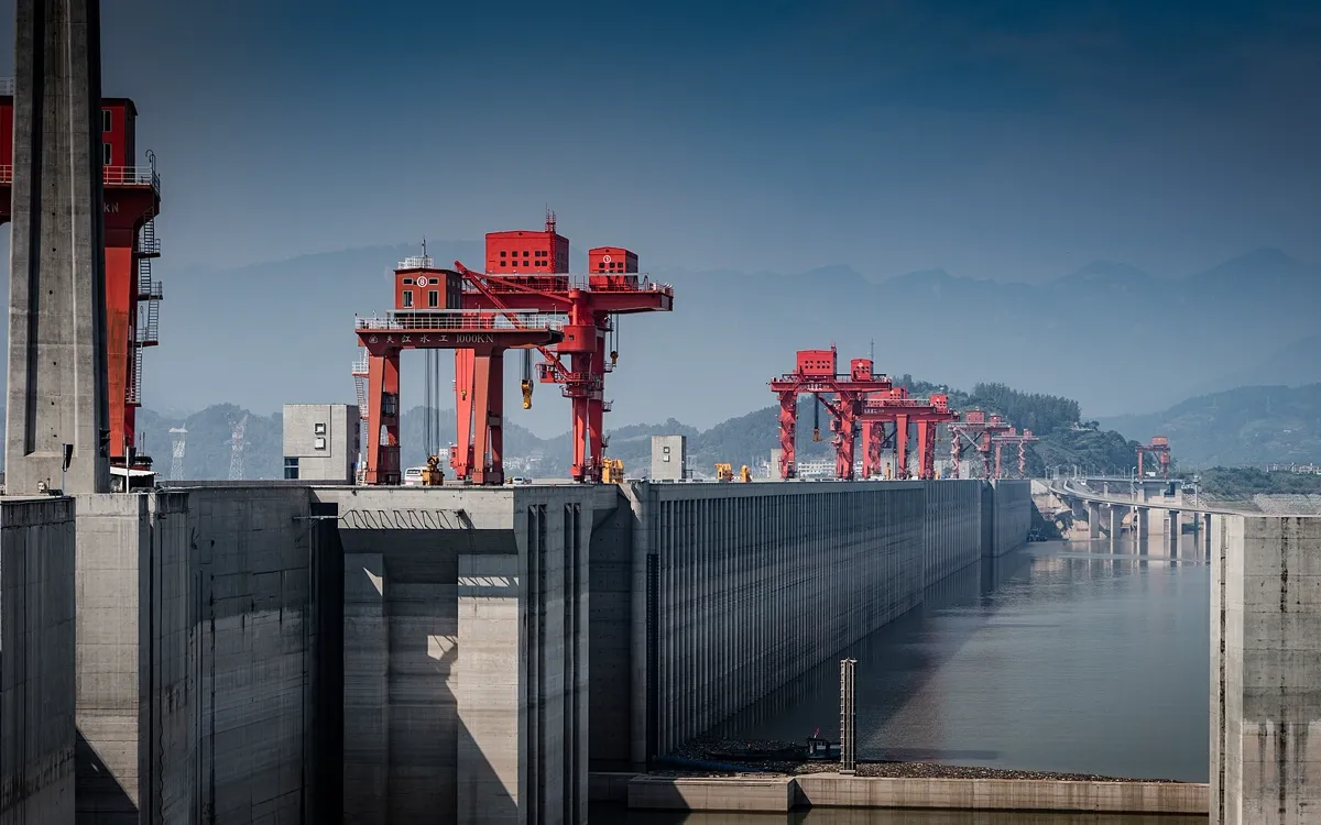 Red gantry cranes along the crest of the Three Gorges Dam above the Yangtze reservoir